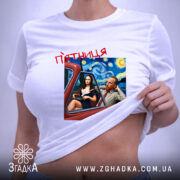 Футболка арт п’ятниця, біла, на столі, з принтом, що зображує двох персонажів у автомобілі на фоні зоряної ночі, текст 'п’ятниця' червоним шрифтом, етикетка на рукаві.