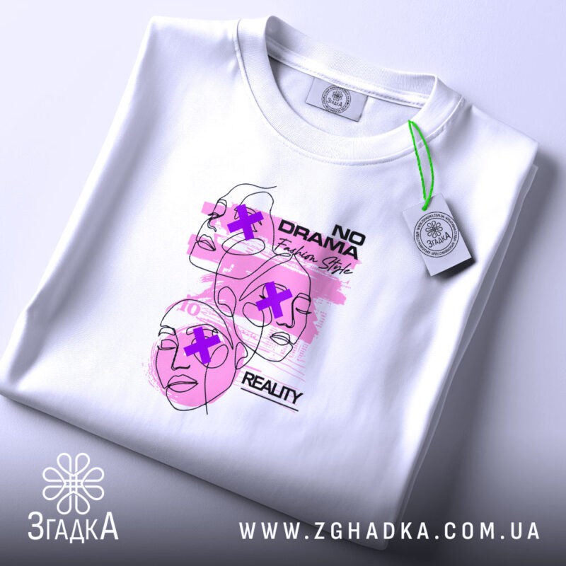 Футболка без драми, біла, на плоскій поверхні, фон світло-фіолетовий, принт з трьома обличчями у стилі лінійного малюнка з рожевими акцентами та текстом 'NO DRAMA', етикетка з зеленим шнурком.