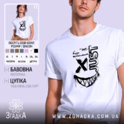 Футболка будь щасливим, біла, на моделі, з коротким рукавом, фон світло-фіолетовий, принт чорного кольору з написом 'just' та усмішкою з зубами.