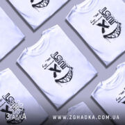 Футболка будь щасливим, біла, на моделі, з коротким рукавом, фон світло-фіолетовий, принт чорного кольору з написом 'just' та усмішкою з зубами.