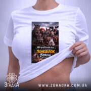 Футболка для роботи в понеділок, біла, складена на поверхні, фон світло-фіолетовий, принт з зображенням тварин на темному фоні з текстом, прикріплена етикетка.