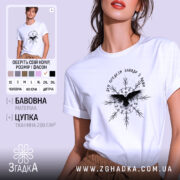 Футболка дух предків, біла, зображена на моделі з легким макіяжем, фон - світло-фіолетовий, принт чорного кольору з птахом та декоративними елементами.