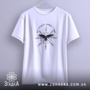 Футболка дух предків, біла, підвішена на вішалці, фон - світло-сірий, принт чорного кольору з птахом та декоративними елементами, широкий крій.