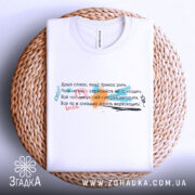 Футболка душа співає, біла, на плетеній основі, з верхнього ракурсу, фон натуральний, принт з текстом у різних кольорах: червоний, зелений, чорний, з елементами графіки.