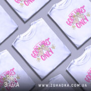 Футболка Good Vibes Only білого кольору, зображена на моделі, яка позує з легким усмішкою на фоні світлого однотонного фону. Принт на футболці містить малюнок двох сов з усмішками та написом 'Good Vibes Only' яскравого рожевого кольору, доповнений жовтими квітами.