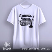 Футболка я янгол, білого кольору, підвішена на вішалці, фон світло-сірий, принт чорного кольору з текстом 'Я янгол. Чесно. Але на мітлі - швидше.' та малюнком мітли.