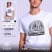 Футболка я обираю гори, біла, на моделі, з принтом у вигляді лісу та місяця, фон світло-сірий, деталі принта чіткі та контрастні.