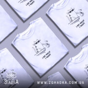 Футболка я роблю що хочу, біла, на моделі, з легким ракурсом спереду, фон світло-фіолетовий, принт з котом у сонцезахисних окулярах, що тримає чашку, текст під принтом чорний.