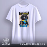 Футболка я сьогодні не в ресурсі. Біла футболка, підвішена на фоні світло-сірого кольору, з принтом чорного кота в окулярах та навушниках, який тримає чашку кави. Принт яскравий, з текстом українською мовою.