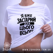 Футболка я вже застарий для цього всього, на столі, біла, з принтом,.