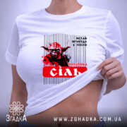 Футболка Йода Сіль, біла, з верхнього ракурсу, фон світло-сірий, принт з зображенням Йоди, текст 'подобана сіль' на червоному фоні, з етикеткою на зеленій стрічці.