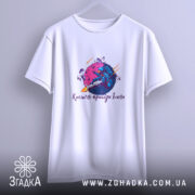 Футболка космічні пригоди Ілона, біла, підвішена на вішалці, з фоном у світло-сірому кольорі, принт з космічним астронавтом, що тримає ракету, на фіолетовій планеті.