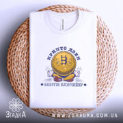 Футболка крипто дзен, біла, на плоскій поверхні, з принтом у вигляді усміхненої монети з символом біткоїна, текстом 'крипто дзен' та 'енергія блокчейну', розташована на плетеній основі, фон світло-сірий.