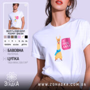 Футболка не проб лама. Біла футболка на моделі, з принтом лами, яка носить блакитний шарф, на фоні світло-сірого кольору. Принт з написом 'НЕ ПРОБ ЛАМА' розташований праворуч від лами.