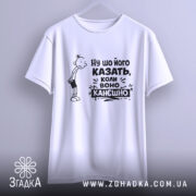 Футболка ну шо його казать, біла футболка, підвішена на вішалці, з принтом, що містить персонажа з сумним виразом обличчя та текстом "Ну шо його казать, коли воно канешно". Фон світло-сірий, футболка має широкий виріз.