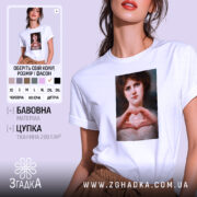 Футболка-оберіг від ідіотів, біла футболка на моделі, з принтом на грудях, який зображує жінку з серйозним виразом обличчя, що формує серце руками, на фоні світло-фіолетового кольору.