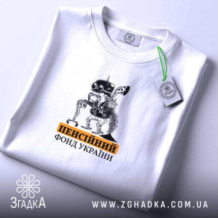 Футболка пенсійний фонд України, біла, складена на поверхні, ракурс зверху, фон світло-сірий, принт з малюнком робота з окулярами та текстом 'пенсійний фонд України' у чорному та оранжевому кольорах, з етикеткою.