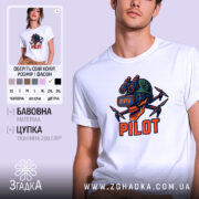 Футболка Пілот FPV білого кольору, зображена на молодому чоловікові, який позує з легким усмішкою. Принт на футболці зображає череп з окулярами віртуальної реальності та дронами, виконаний в яскравих кольорах: червоному, зеленому та чорному. Фон м'який, пастельний, що підкреслює деталі принта.