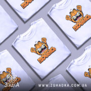 Футболка посміхнись мультяшний стиль, біла, на столі, кілька футболок, принт з Гарфілдом,.