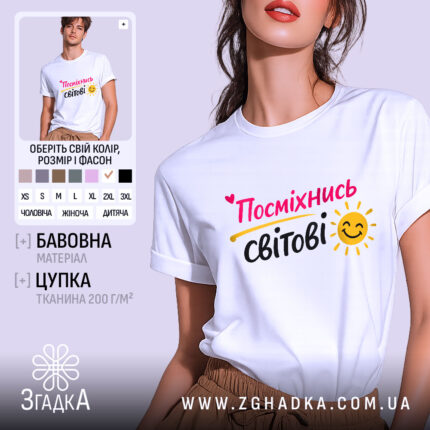 Футболка посміхнись світові, біла, зображена на моделі з легким ракурсом, фон пастельного кольору, принт з написом 'Посміхнісь світові' у яскравих кольорах з усмішкою та сонечком.