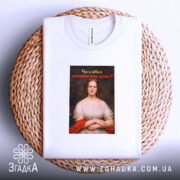 Футболка проти непроханих порад. Біла футболка, складена на плетеній кошику, фон світлий. Принт з портретом жінки в червоній сукні, текст на принті чорний з червоним, запитує: 'Чи я вбиса запитувала вашу думку?'.