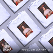 Футболка проти непроханих порад. Біла футболка на моделі, зображена в анфас, фон світло-фіолетовий. Принт з портретом жінки в червоній сукні, текст на принті чорний з червоним, запитує: 'Чи я вбиса запитувала вашу думку?'.