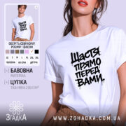 Футболка щастя прямо перед вами, біла, з коротким рукавом, зображена на моделі, фон світло-фіолетовий, принт чорний з написом 'Щастя прямо перед вами' у стилі графіті.