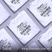 Футболка шукаю того самого, біла, на моделі, з коротким рукавом, фон світло-сірий, принт чорний з текстом та декоративними елементами.