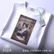 Футболка слуги працюють, біла, зображена зверху, фон світло-сірий, принт з котом у костюмі з короною, який тримає чашку, а з боків два ангели, один з них тримає чайник, а інший поправляє корону, на футболці є етикетка.