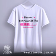 Футболка старша сестра, біла, на вішалці, фон світло-сірий, принт з написом 'Рівень: СТАРША СЕСТРА' та графіком завантаження в рожевих відтінках.