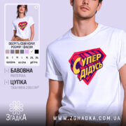 Футболка супер дідусь, біла, на моделі, з легким ракурсом спереду, фон пастельного кольору, принт у вигляді червоного герба з жовтим написом 'Супер дідусь'.