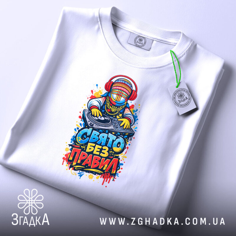 Футболка свято без правил, біла, лежить на плоскій поверхні, фон світло-фіолетовий, принт з діджеєм, яскраві кольори, етикетка з зеленим шнурком.