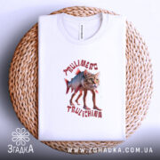 Футболка Trulimero Trulichina білого кольору, складена на плетеній кошику, принт з котом і рибою, текст виконаний червоним кольором, фон світлий.