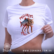 Футболка Trulimero Trulichina білого кольору, складена на поверхні, принт з котом і рибою, текст виконаний червоним кольором, на футболці є етикетка з зеленим шнурком.