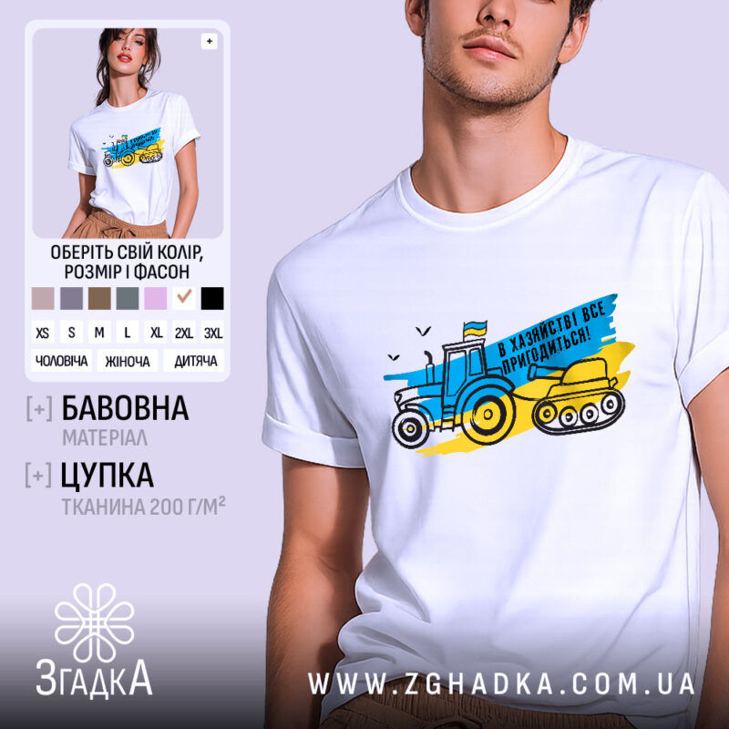 Футболка в хазяйстві все пригодиться. Біла футболка на чоловікові з коротким рукавом, ракурс спереду, фон світло-фіолетовий. Принт з трактором і танком у жовто-блакитних кольорах, текст "В хазяйстві все пригодиться!".