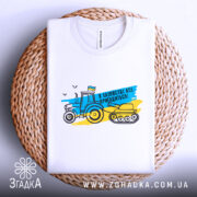 Футболка в хазяйстві все пригодиться. Біла футболка, складена на плетеній основі, фон світло-сірий. Принт з трактором і танком у жовто-блакитних кольорах, текст "В хазяйстві все пригодиться!".