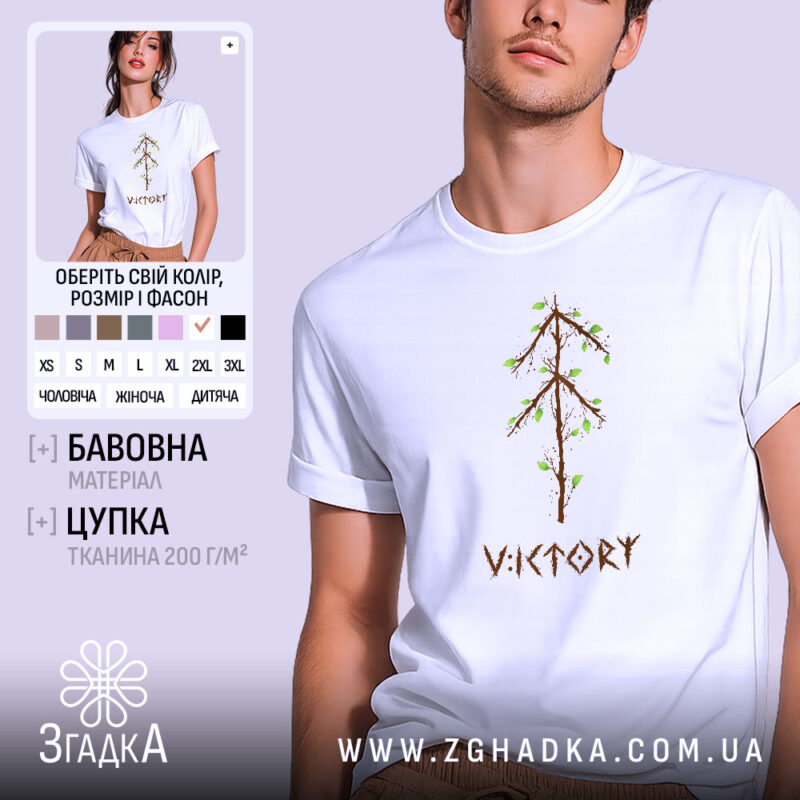 Футболка VIKTORY білого кольору, зображена на молодій людині, яка позує в три чверті, фон світло-фіолетовий. Принт у вигляді дерева з коричневими гілками та зеленим листям, розташований по центру, під ним напис 'VIKTORY' коричневого кольору.