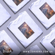 Футболка вір у маленькі чудеса, біла, на столі, кілька футболок, принт з.