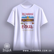 Футболка вождь племені, біла, підвішена на вішалці, фон світло-сірий, принт з текстом "Усі індіанці як індіанці, а я вождь" з декоративними елементами, такими як стріла та листя.