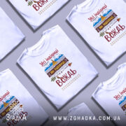 Футболка вождь племені, біла, зображена на молодому чоловіку, фон світло-фіолетовий, принт містить текст "Усі індіанці як індіанці, а я вождь" з елементами гір, намету та стріл.