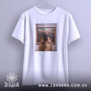 Футболка видатні українці, біла, на вішалці, з принтом, що зображує жінку, яка дивиться на групу чоловіків у картині, фон світло-сірий, деталі принта чіткі, зображення в золотій рамі.