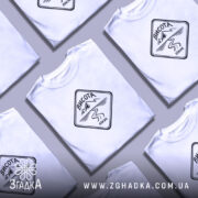 Футболка висота лікує. Біла футболка з коротким рукавом, зображена на молодій людині, фон світло-фіолетовий, принт чорного кольору з написом 'ВИСОТА лікує' та малюнком гір і дороги.