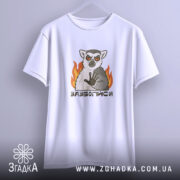 Футболка зазбогійся з лемуром, біла, підвішена на вішалці, фон світло-сірий, принт з лемуром з червоними очима та вогнем.