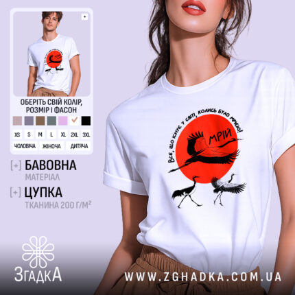 Футболка журавлі та мрія, біла футболка на моделі, зображена з близького ракурсу, фон світло-сірий, принт містить червоне сонце та журавлів, текст на футболці українською мовою.