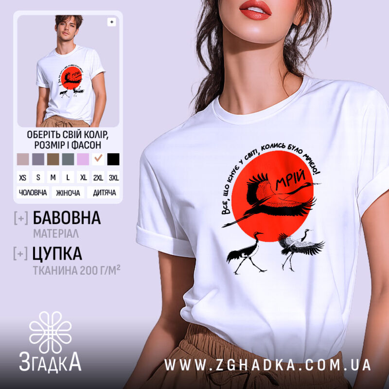 Футболка журавлі та мрія, біла футболка на моделі, зображена з близького ракурсу, фон світло-сірий, принт містить червоне сонце та журавлів, текст на футболці українською мовою.