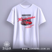 Футболка жигастайл білого кольору, підвішена на вішалці. Принт з червоним автомобілем та написом 'Жигастайл' у червоному кольорі, фон виконаний у сірому кольорі з хмарами. Футболка має вільний крій.