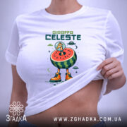 Футболка Жирафа Селесте на білому фоні, зображена в плоскому вигляді, принт з жирафом у космічному шоломі на кавуні, з яскравими оранжевими черевиками, на етикетці видно логотип бренду, фон світло-сірий.