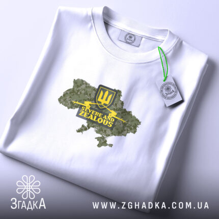 Футболка ЗСУ стиль, складена біла футболка з принтом у вигляді карти України, жовтий герб тризуба та напис 'Severe and Zealous', фон світлий, футболка лежить на поверхні.