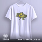 Футболка ЗСУ стиль, біла футболка підвішена на вішалці, з принтом у вигляді карти України, жовтий герб тризуба та напис 'Severe and Zealous', фон світло-сірий, футболка має вільний крій.