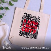 Шопер я хуїю з цього світу, бежевий, на столі з рослинами, бренд.